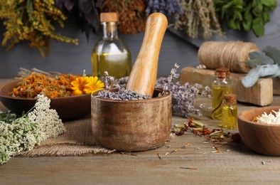 Mortar with pestle and dry lavender flowers on wooden table. Medicinal herbs