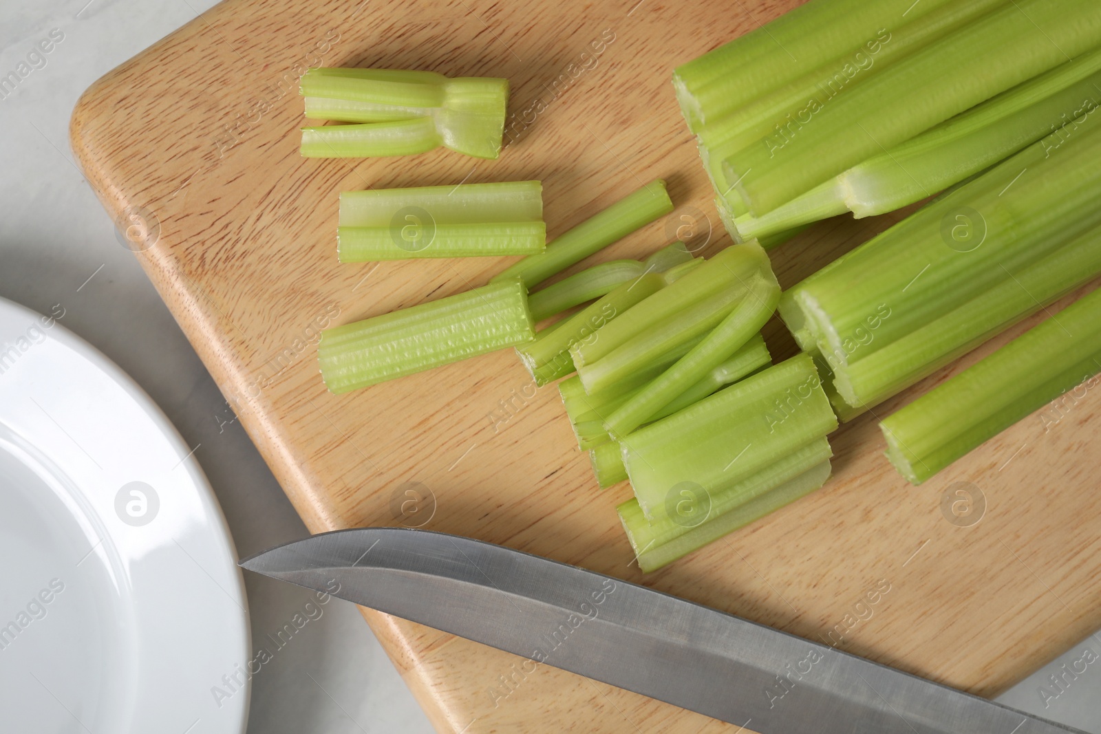 Photo of Fresh ripe green celery on white table, flat lay