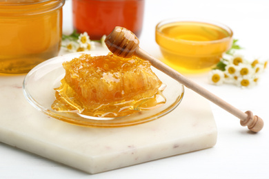 Photo of Tasty honey comb on light marble board, closeup