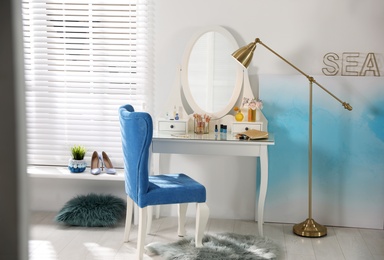 Photo of Elegant dressing table and blue chair in stylish room interior