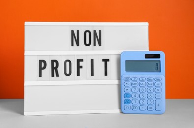 Photo of Lightbox with phrase Non Profit and calculator on white table