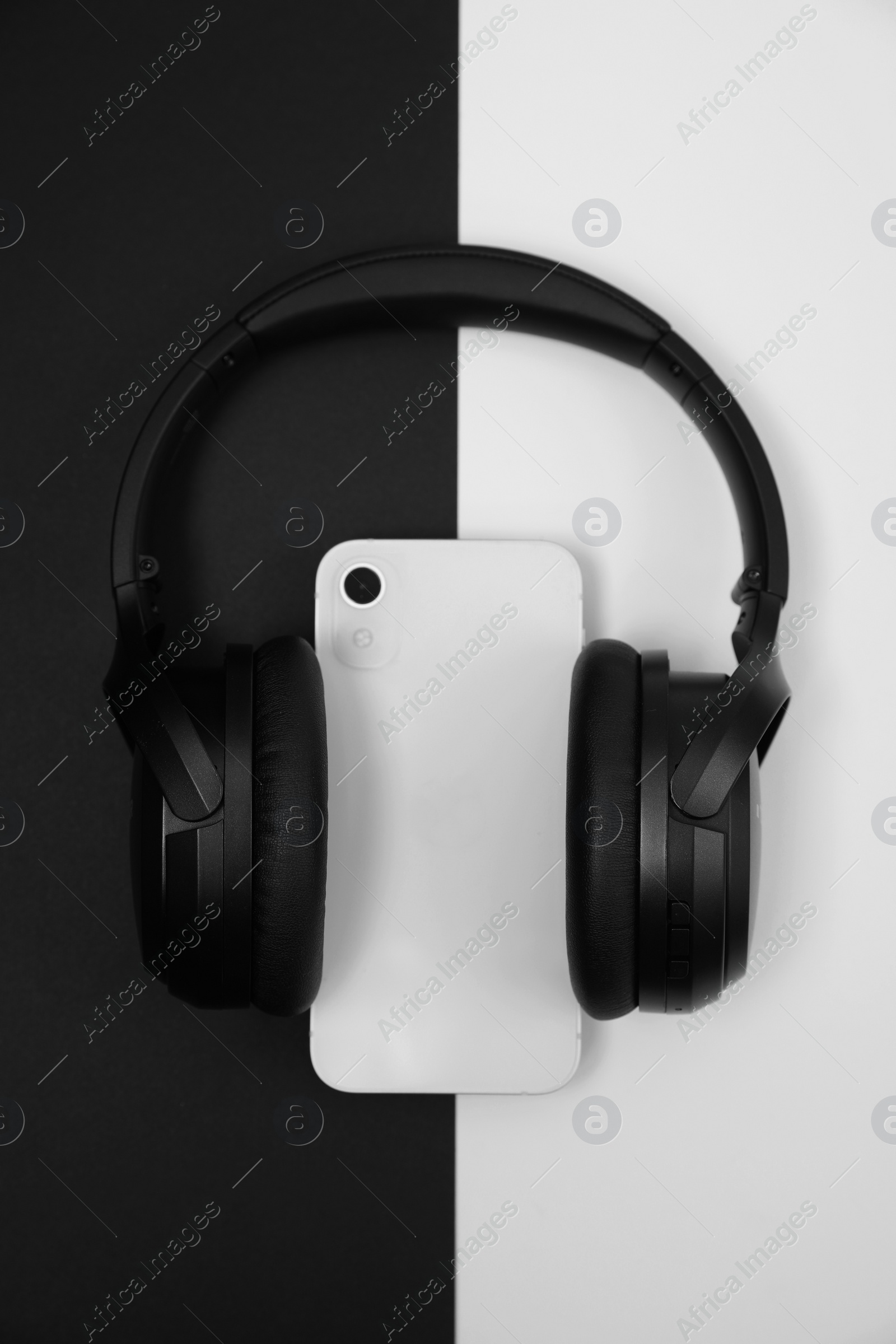 Photo of Modern wireless headphones and smartphone on color background, top view