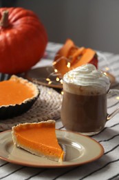 Photo of Fresh homemade pumpkin pie and cup of cocoa with whipped cream on table