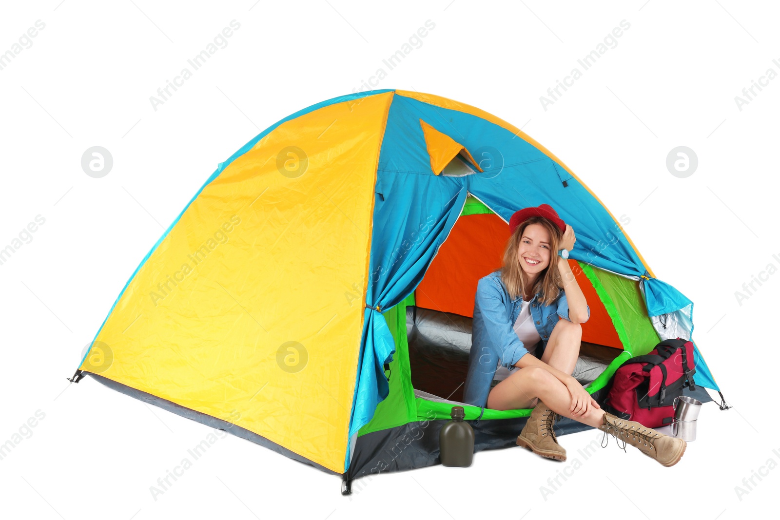 Photo of Young beautiful woman sitting in tourist tent on white background