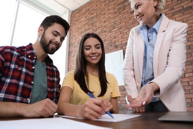 Female notary working with young couple in office