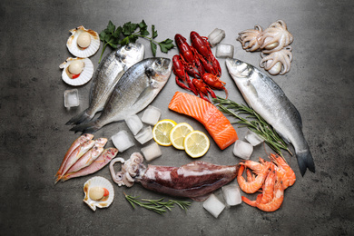 Photo of Fresh fish and seafood on grey table, flat lay