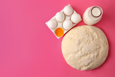 Photo of Raw dough and ingredients for pastries on pink background, flat lay. Space for text