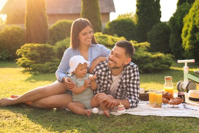 Photo of Happy family having picnic in garden on sunny day