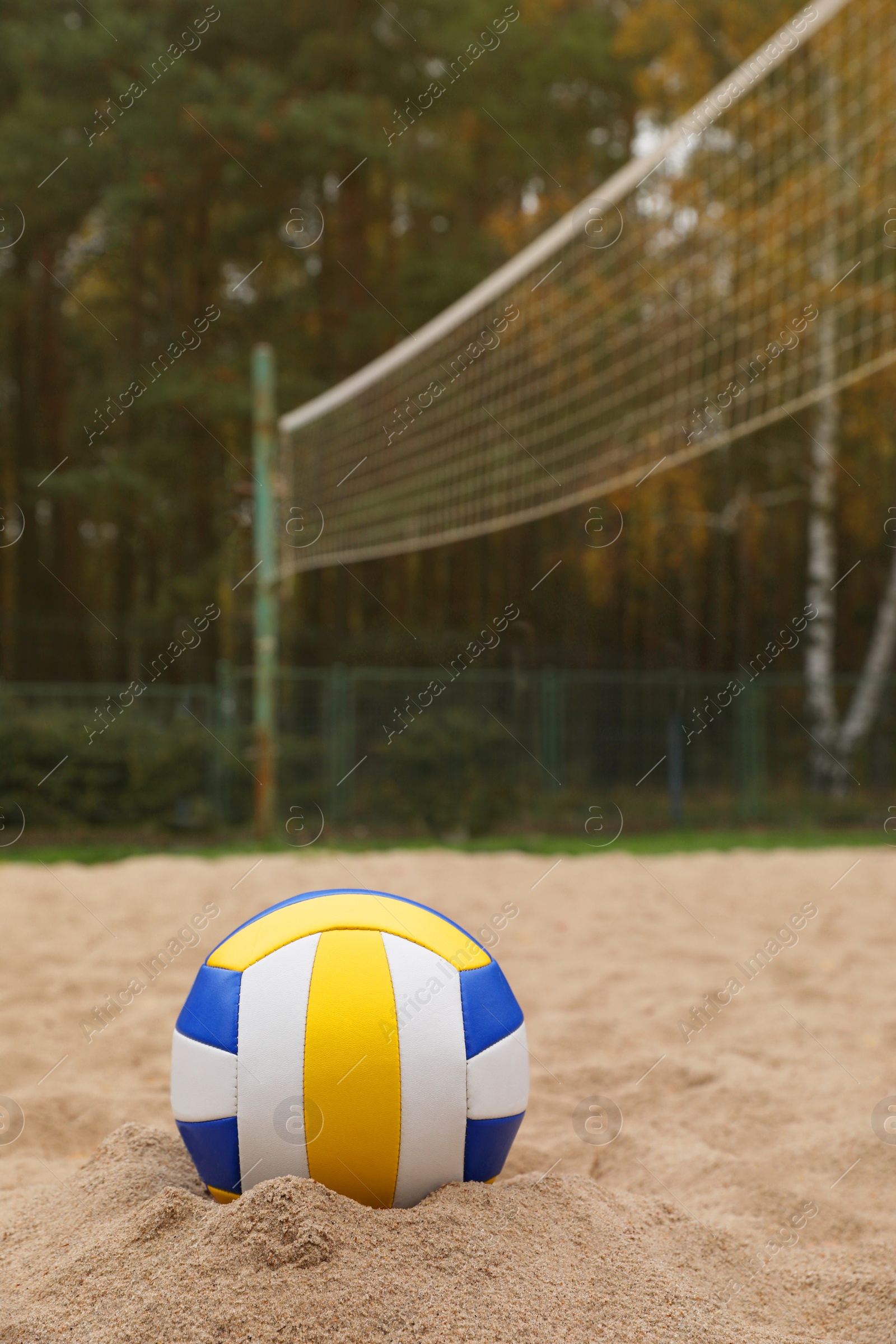 Photo of Colorful volleyball ball on sand court, space for text