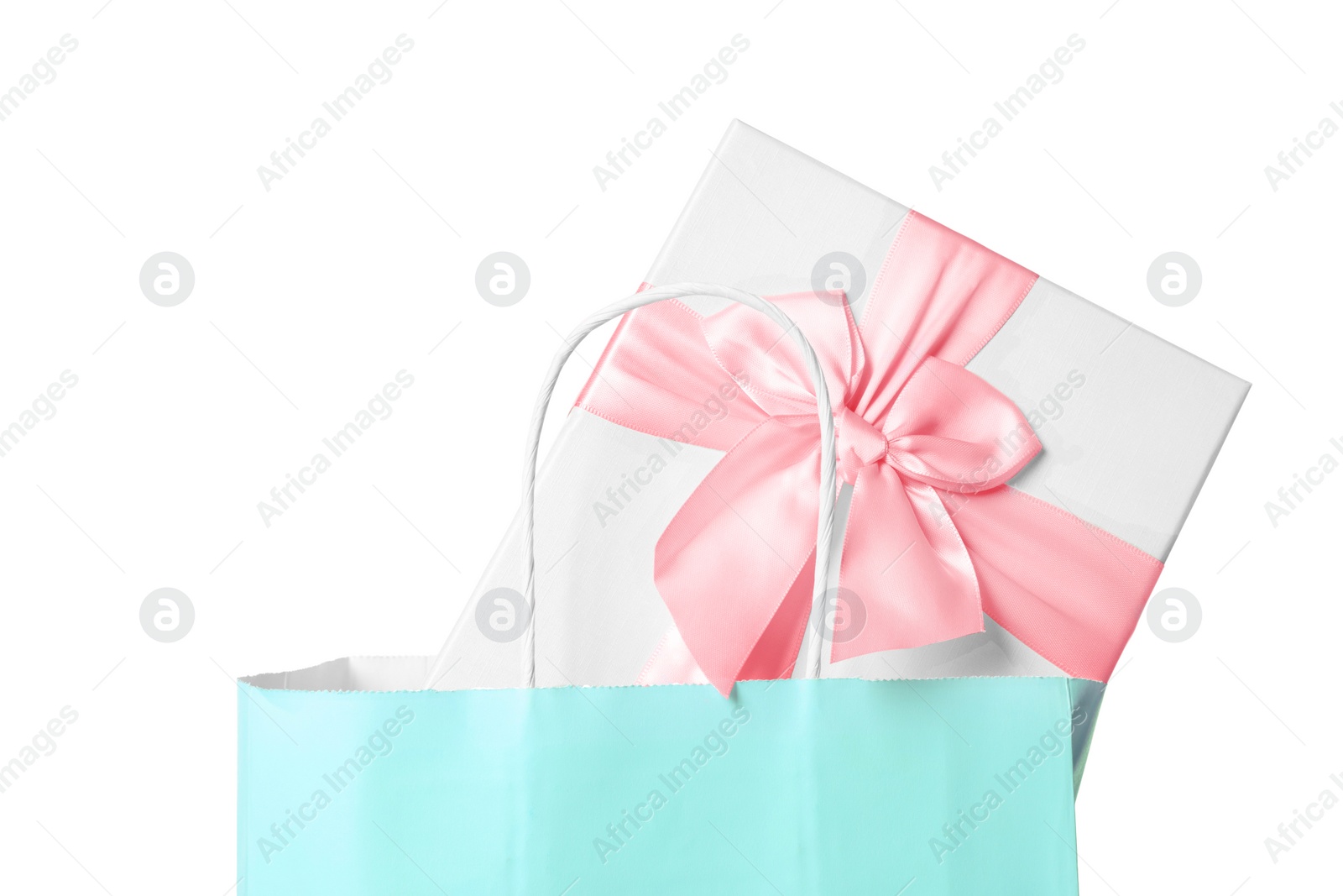 Photo of Light blue paper shopping bag with gift box on white background, closeup