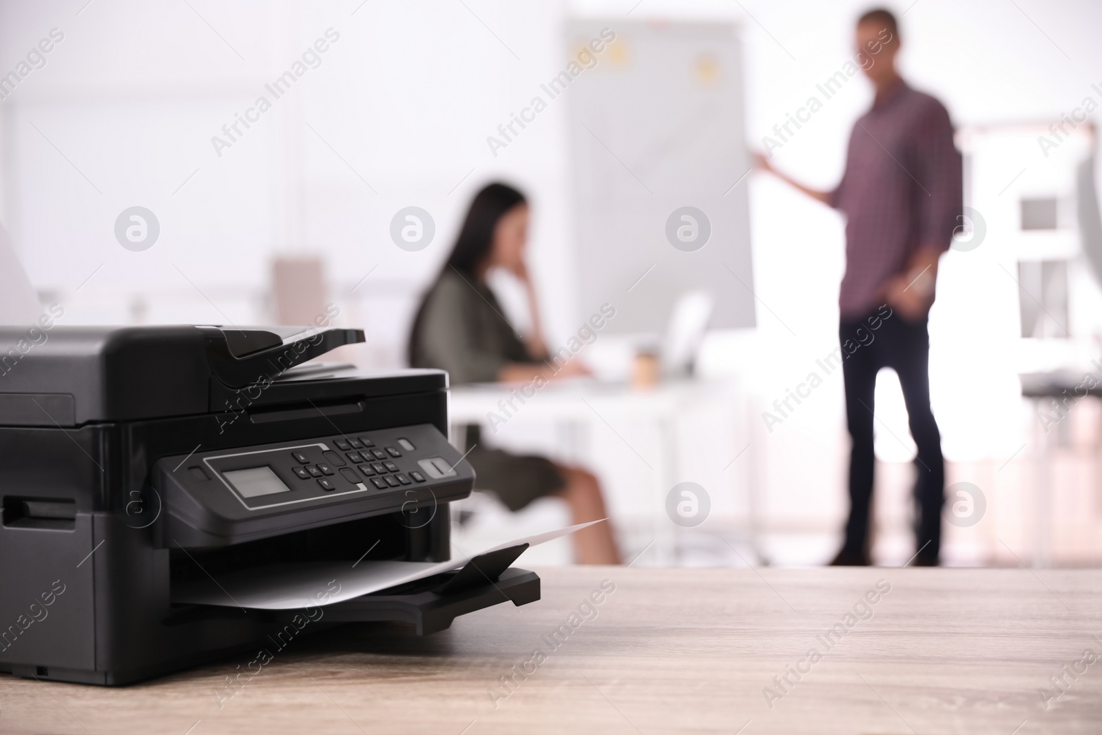 Photo of New modern printer on table in office. Space for text