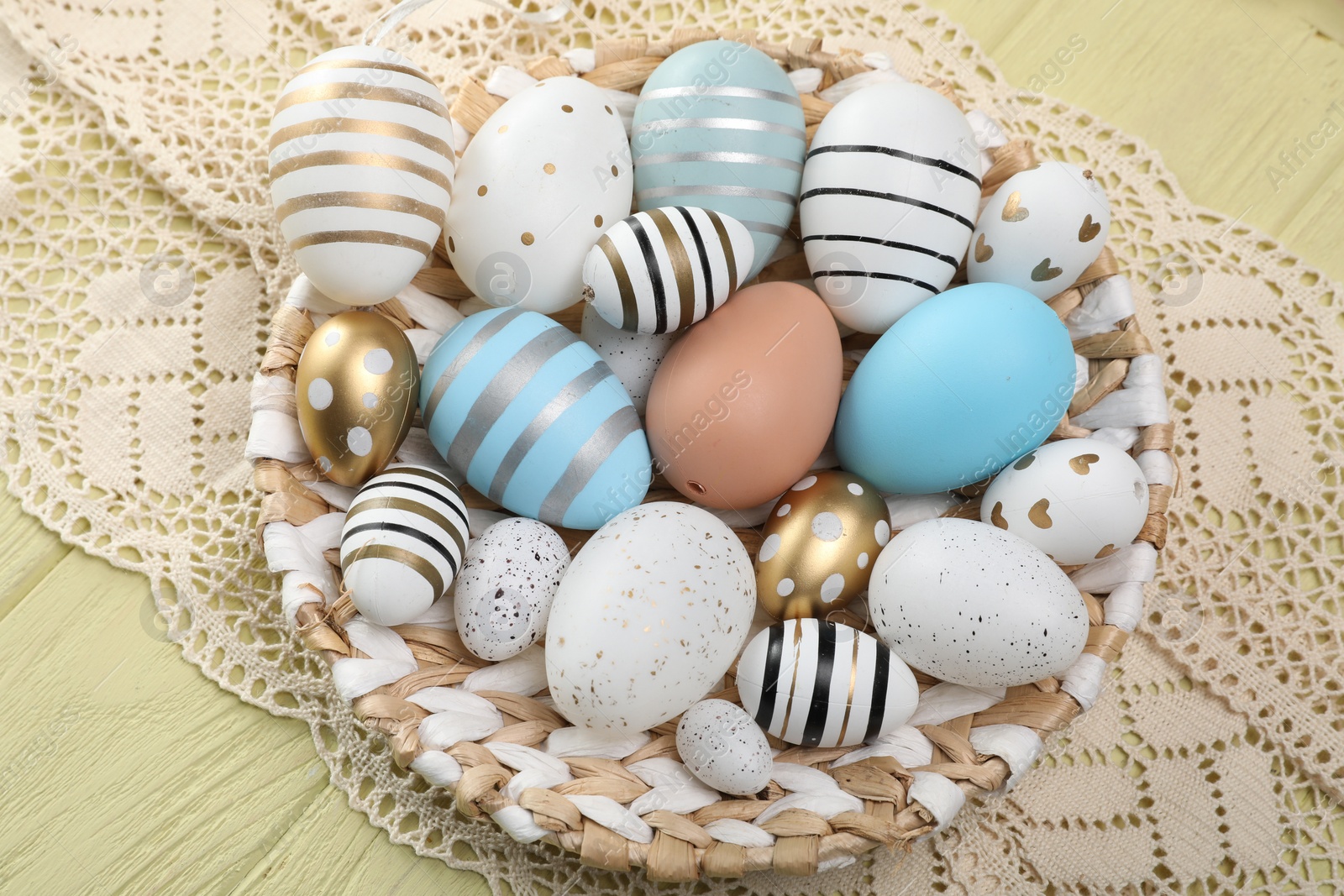 Photo of Many beautifully decorated Easter eggs on wooden table, top view