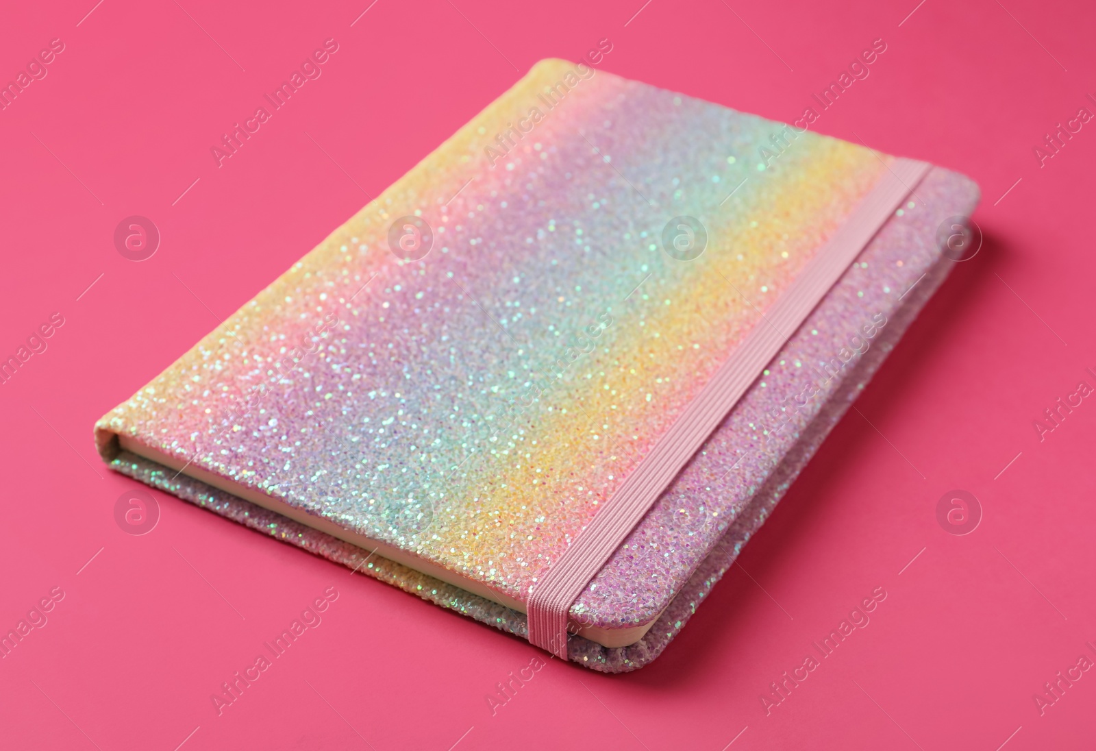 Photo of New stylish planner with hard cover on pink background, closeup