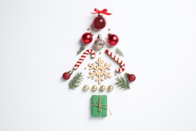 Christmas tree silhouette of fir branches and festive decoration on white background, top view