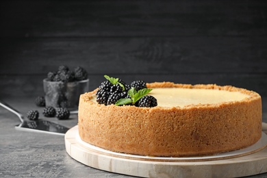 Delicious cheesecake decorated with blackberries on table