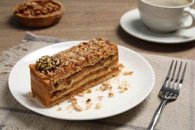 Plate with delicious layered honey cake on table
