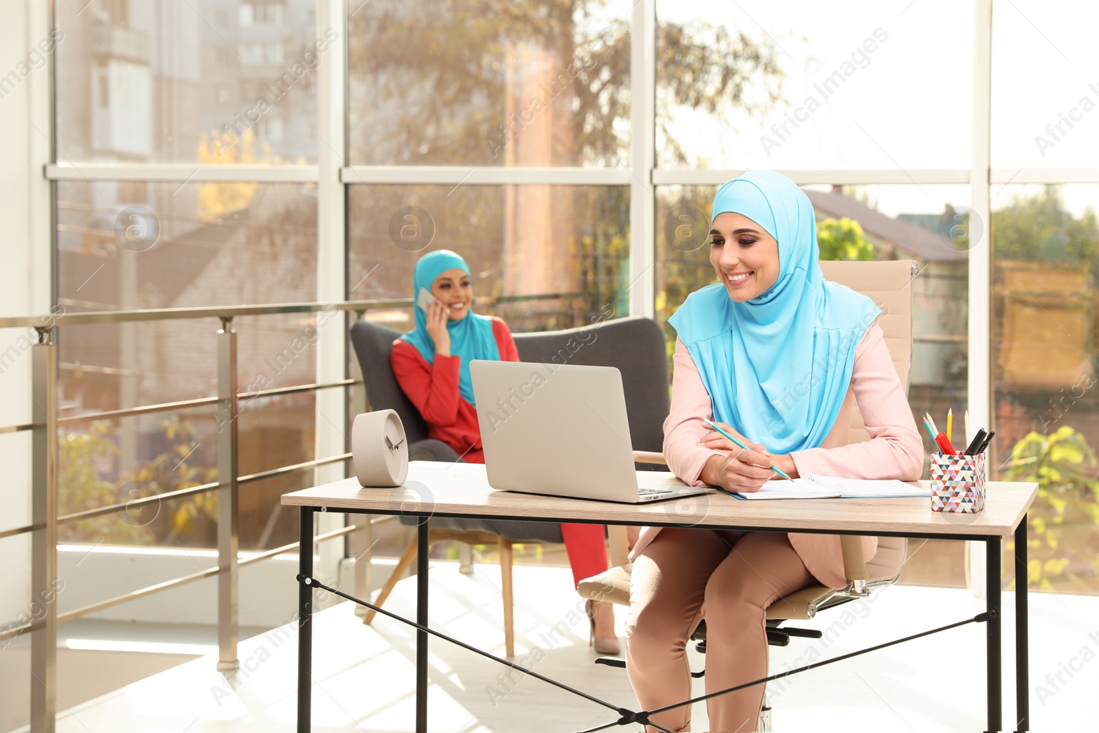 Photo of Modern Muslim women working in light office