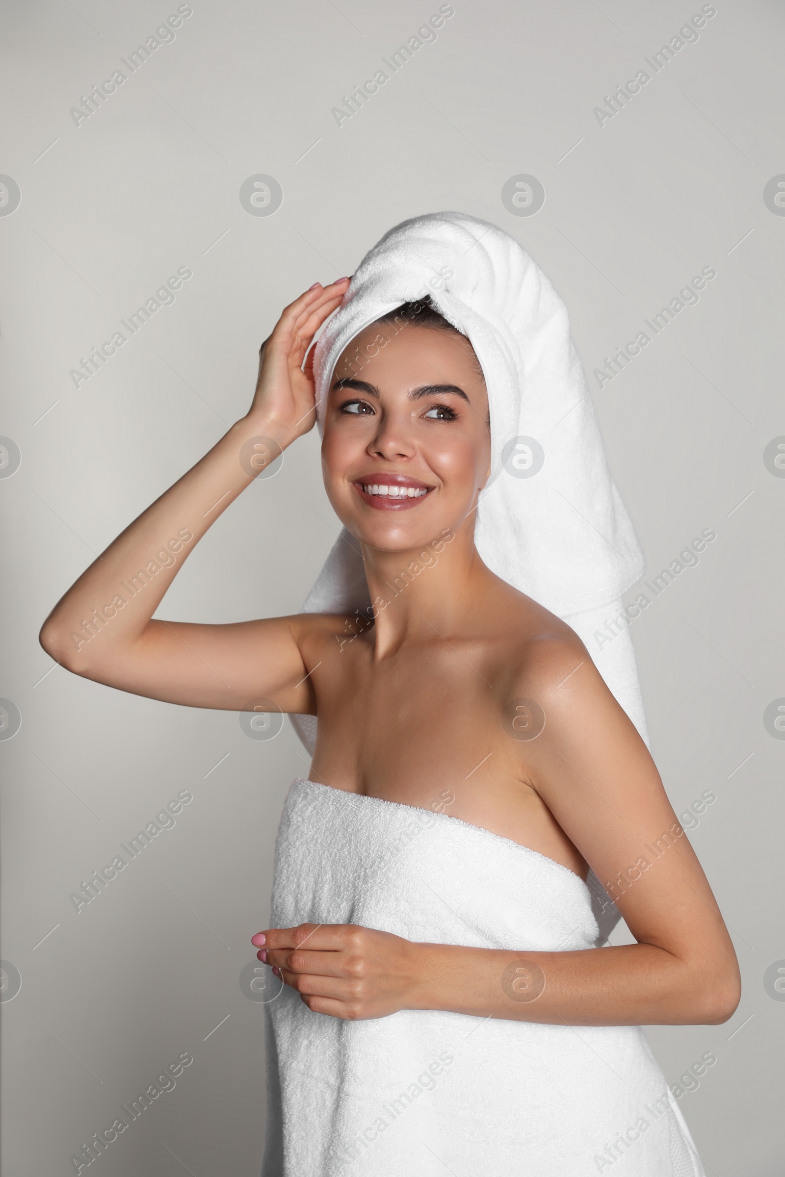 Photo of Beautiful young woman with towels on light background