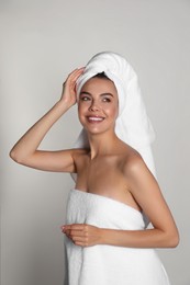 Photo of Beautiful young woman with towels on light background