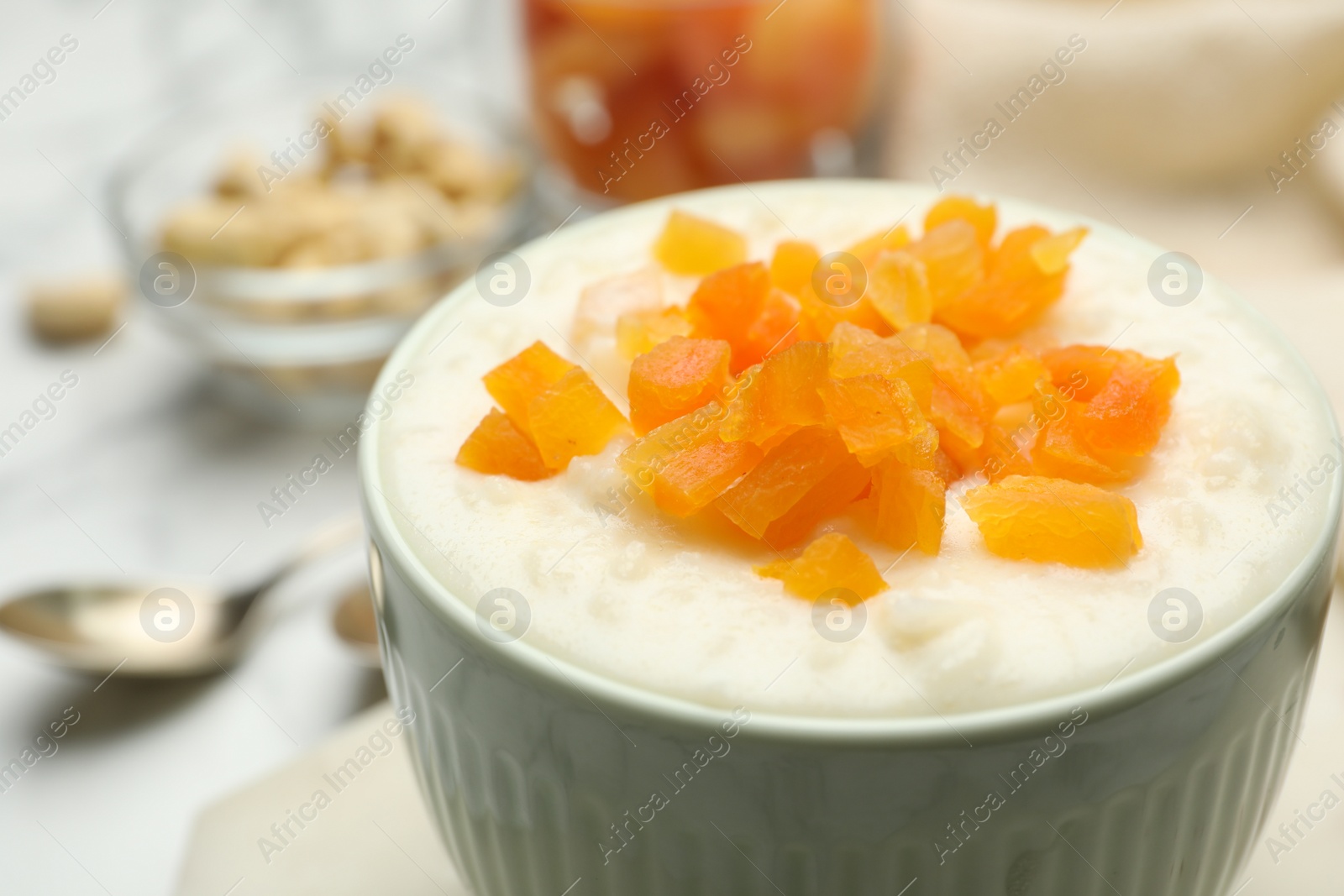 Photo of Delicious rice pudding with dried apricots, closeup