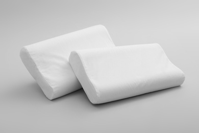 Clean soft orthopedic pillows on grey background