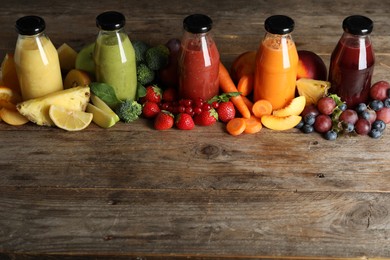 Photo of Bottles of delicious juices and fresh fruits on wooden table. Space for text