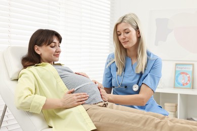 Pregnancy checkup. Doctor measuring patient's tummy in clinic