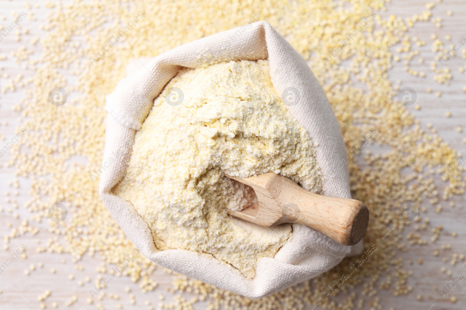 Photo of Sack with quinoa flour, scoop and seeds on white wooden table, top view