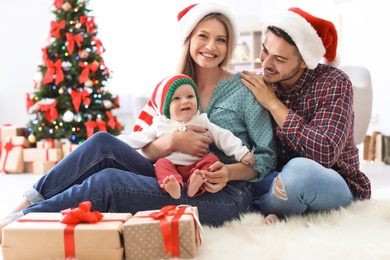 Photo of Happy couple with baby celebrating Christmas together at home