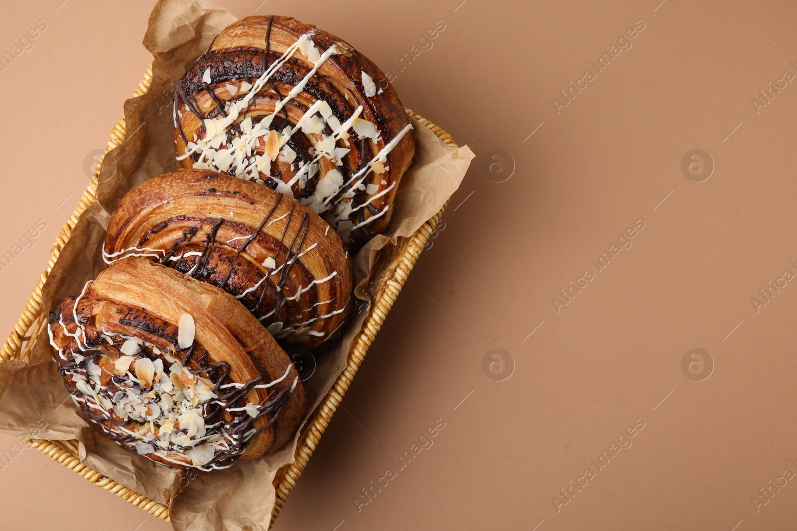 Photo of Sweet buns. Delicious rolls with toppings and almond on beige table, top view. Space for text