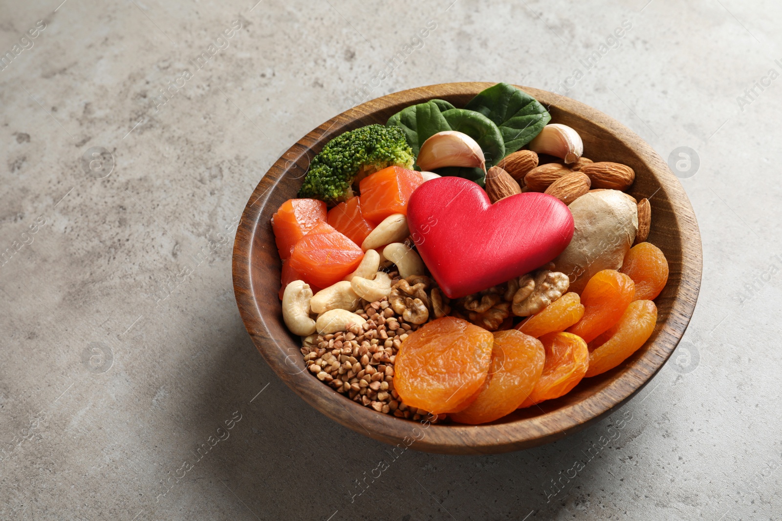 Photo of Bowl with heart-healthy products on grey background, space for text