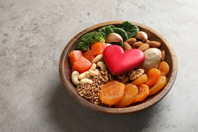Photo of Bowl with heart-healthy products on grey background, space for text