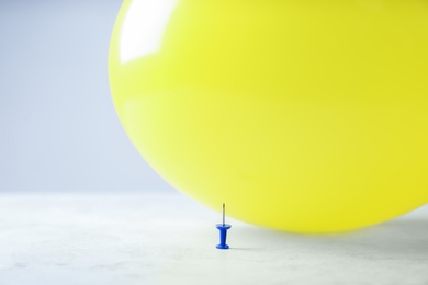 Photo of Color balloon and pin on table against white background, space for text