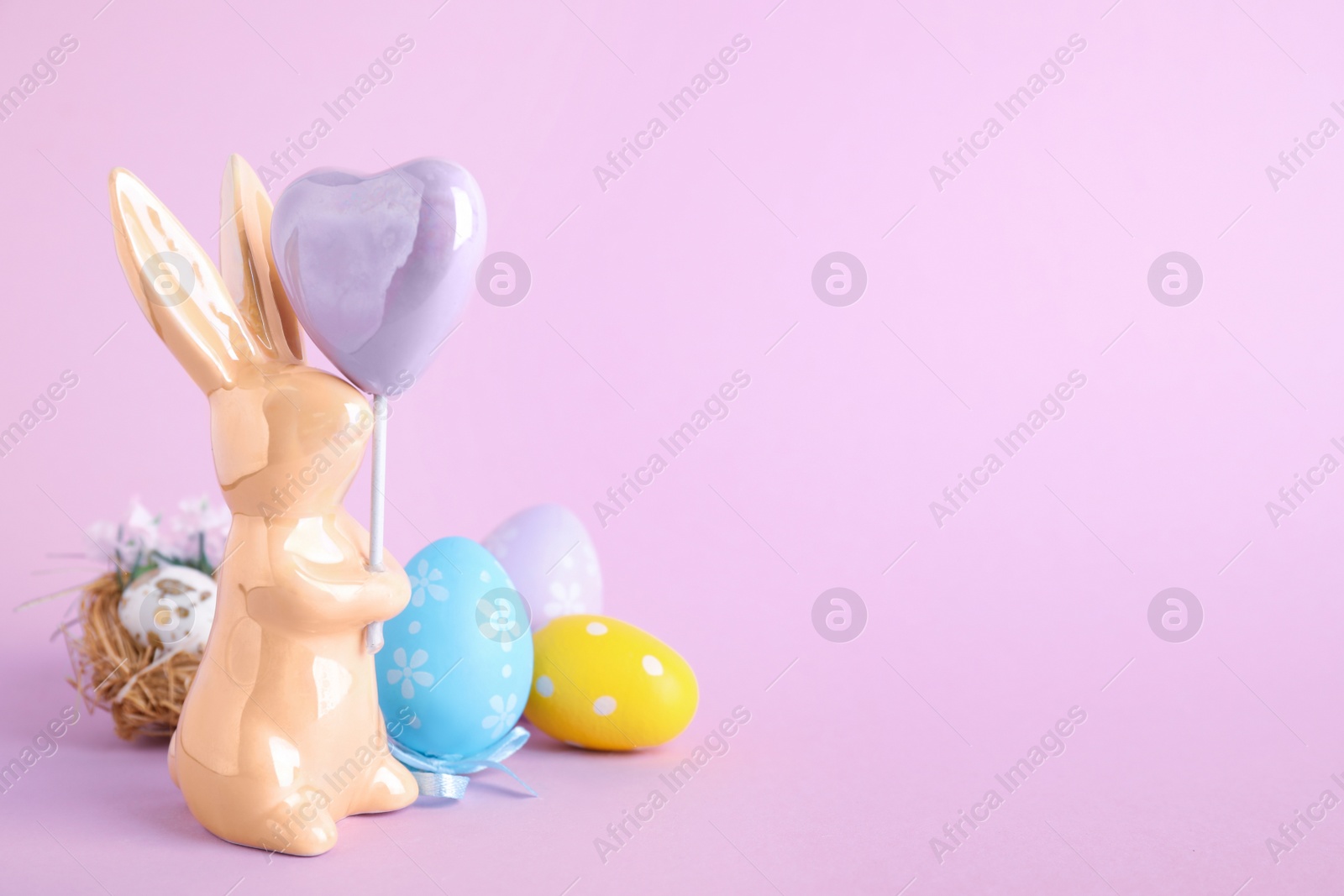 Photo of Composition with Easter bunny figure on violet background. Space for text