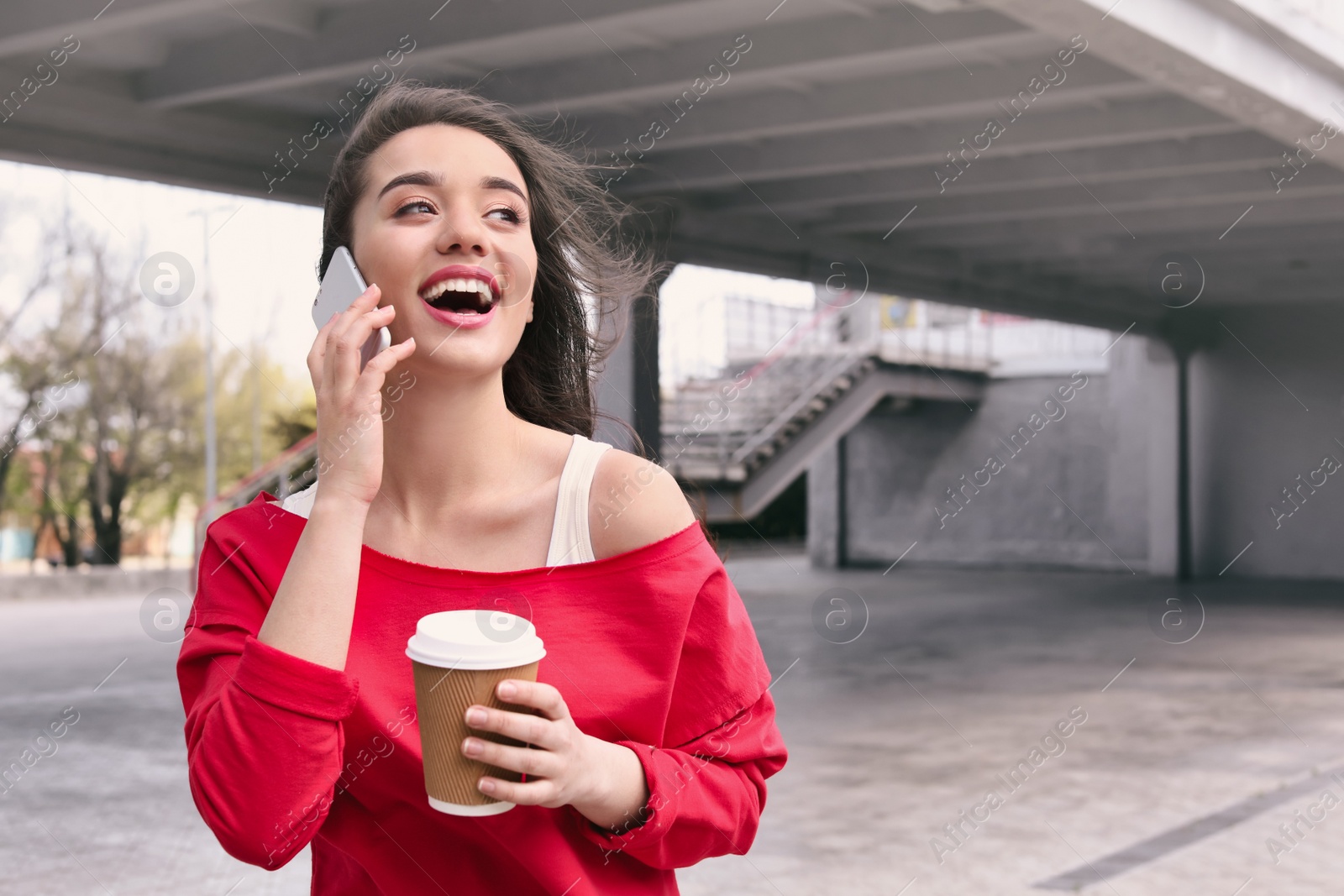 Photo of Young woman talking on mobile phone outdoors