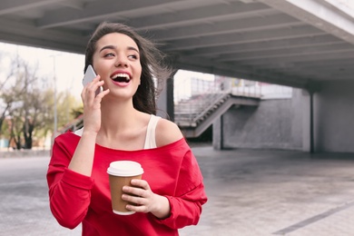 Photo of Young woman talking on mobile phone outdoors