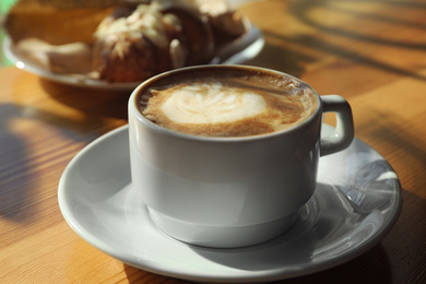 Photo of Cup of fresh aromatic coffee at table in cafe