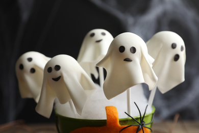 Photo of Ghost shaped cake pops on dark background, closeup. Halloween treat