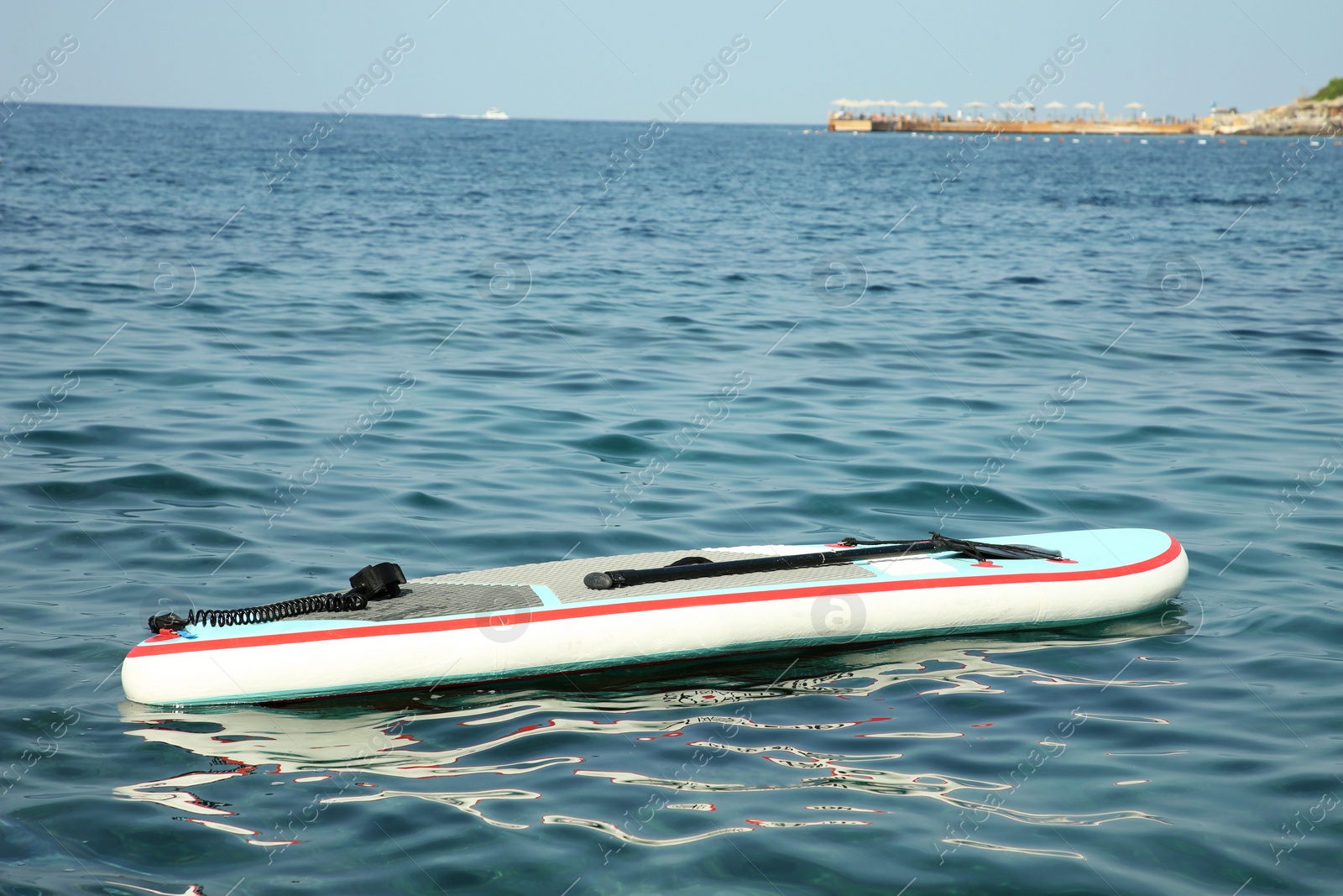 Photo of One SUP board with paddle on sea water