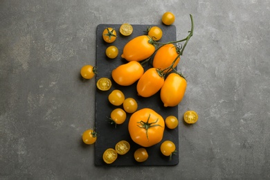 Photo of Ripe yellow tomatoes on grey table, flat lay