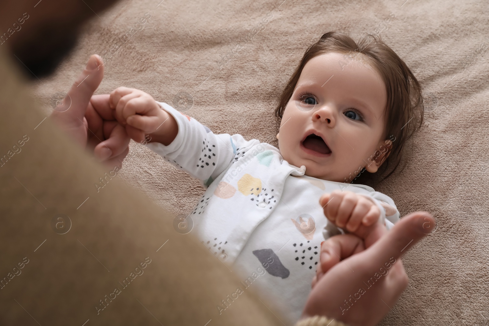 Photo of Father playing with his daughter on blanket, closeup