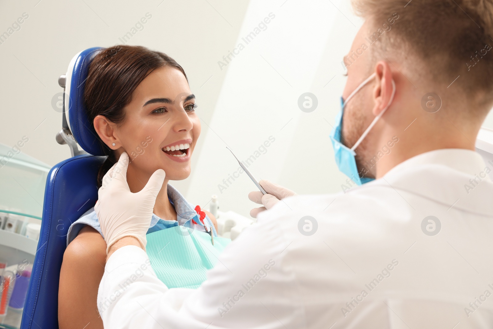 Photo of Professional dentist working with patient in clinic