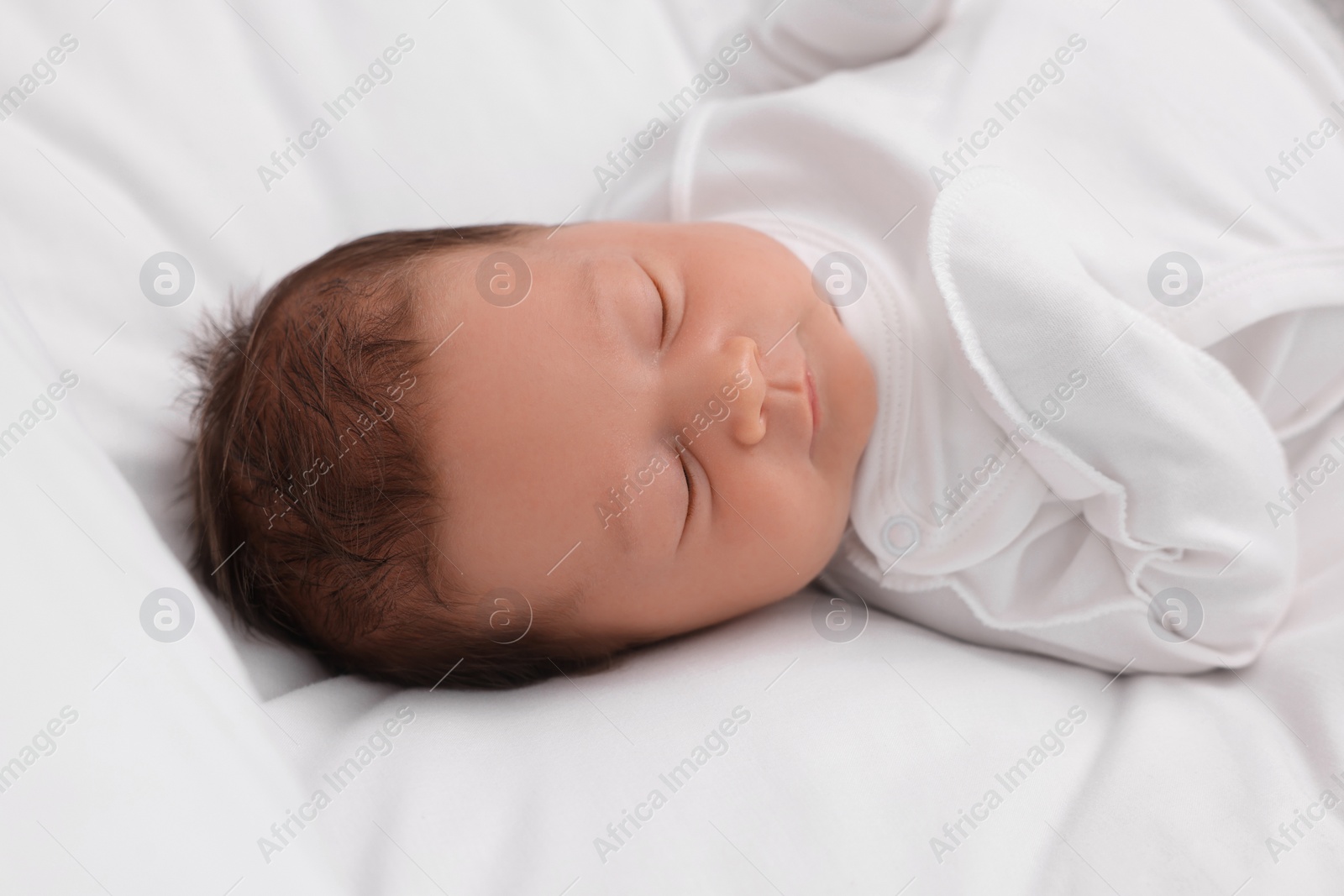 Photo of Cute newborn baby sleeping on white bed