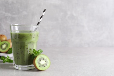 Delicious kiwi smoothie and fresh fruits on light grey table. Space for text