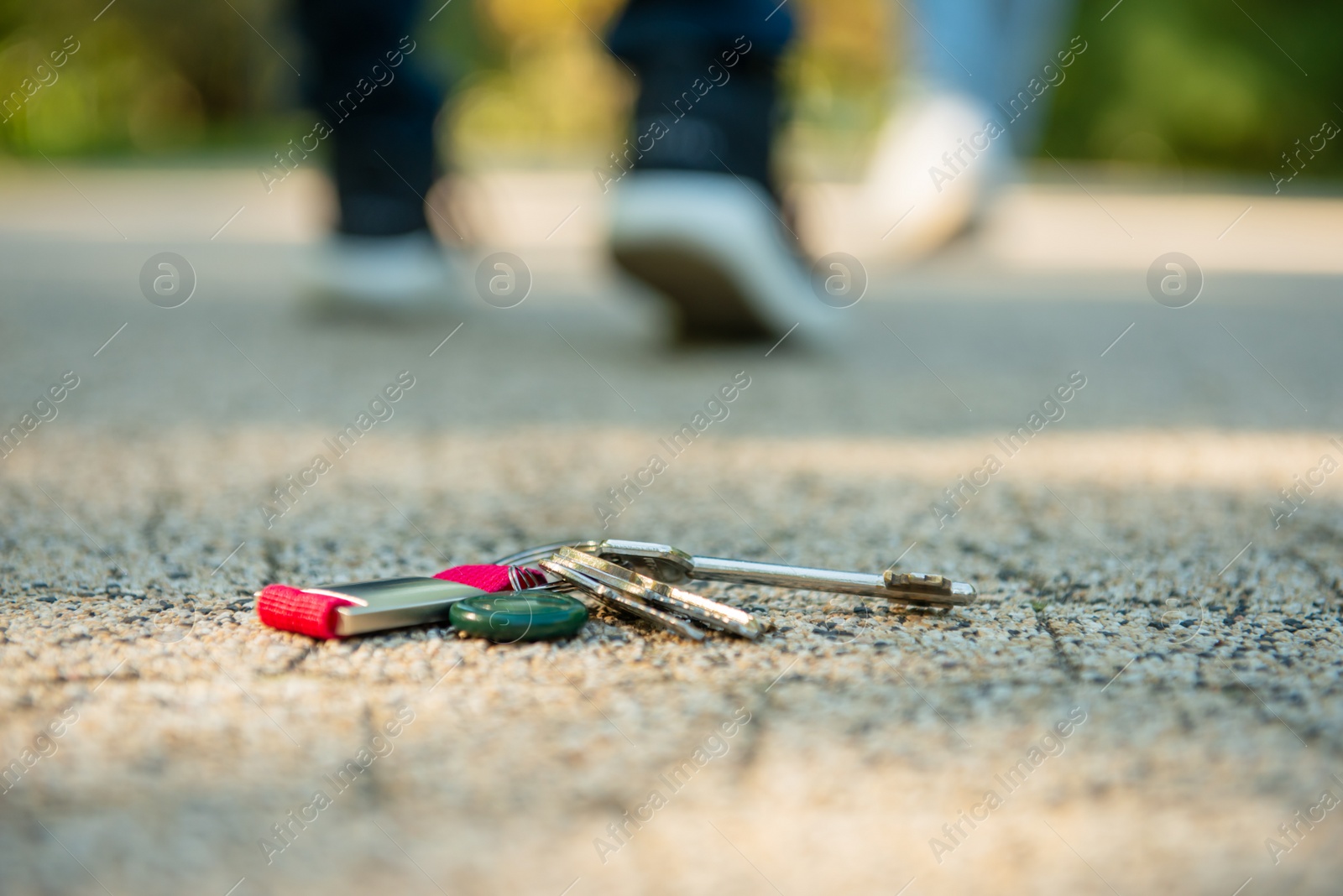 Photo of Men walking outside, focus on lost keys