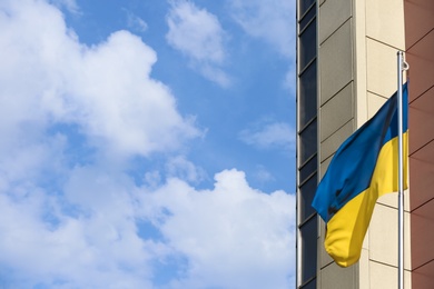 Photo of Ukrainian flag and building against cloudy sky