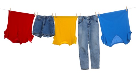 Different clothes drying on laundry line against white background