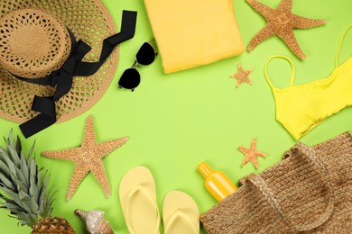 Photo of Frame of beach objects on green background, flat lay. Space for text