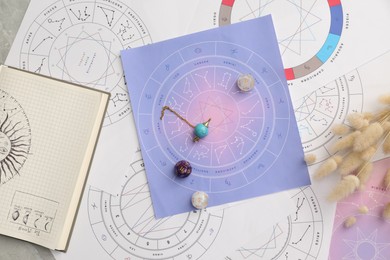 Photo of Natal charts for making forecast of fate and astrological items for fortune telling on table, flat lay