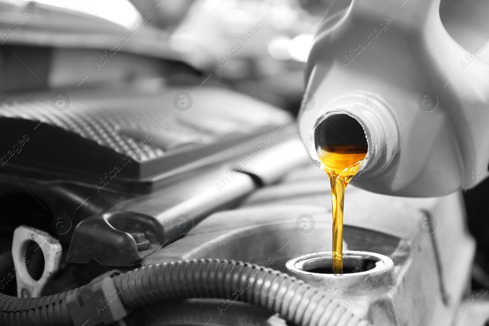 Photo of Pouring oil into car engine, closeup